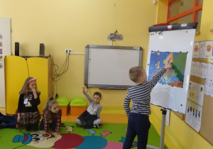 Chłopiec wskazuje na mapie jeden z krajów Unii Europejskiej.